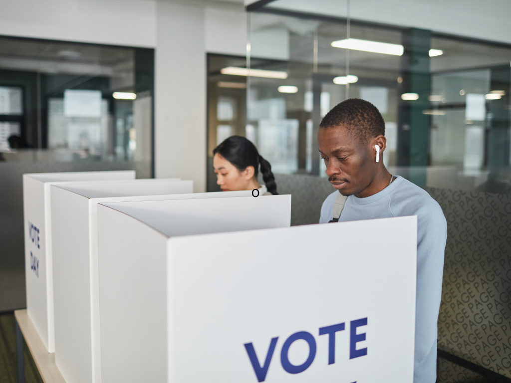 Vai trabalhar no dia da eleição? Patrão pode descontar as horas para votar? Quem precisa trabalhar no dia da eleição pode sair do trabalho para votar. Mas fica uma dúvida: o patrão pode descontar do salário as horas que o empregado ficou fora? A resposta é não, desde que o tempo seja necessário para o trabalhador votar. Quem trabalha no dia da eleição pode sair para votar? Sim. A legislação eleitoral garante ao trabalhador o direito de se ausentar do serviço pelo tempo necessário para votar, sem desconto no salário. Isso vale para quem estiver trabalhando no horário da votação, inclusive quem trabalha aos domingos. O trabalhador deve considerar o tempo necessário para ir até o local de votação, votar e retornar ao trabalho. O patrão pode descontar essas horas? Não deve haver desconto pelo período utilizado para votar. A regra não significa que o empregado possa faltar o dia inteiro. O direito é ao tempo necessário para votar. Por isso, se a pessoa trabalha durante o horário de votação, deve organizar sua saída de forma que consiga votar e retornar ao trabalho. Preciso avisar a empresa? É recomendável avisar o empregador com antecedência, principalmente quando o horário de trabalho coincidir com o horário de votação. Assim, a empresa pode organizar a escala e o trabalhador pode combinar o melhor horário para sair e retornar. E quem é mesário? A situação do mesário é diferente. Quem é convocado pela Justiça Eleitoral para trabalhar nas eleições tem direito a dois dias de folga para cada dia de convocação e efetiva participação, sem prejuízo do salário. Portanto: Vai apenas votar: tem direito ao tempo necessário para votar, sem desconto salarial. Foi convocado como mesário: tem direito às folgas previstas pela Justiça Eleitoral. Pode faltar o dia inteiro para votar? Não. A lei garante o tempo necessário para votar, e não uma folga durante todo o expediente. Por isso, o trabalhador deve usar apenas o período necessário para ir ao local de votação, votar e retornar ao trabalho. E se a empresa descontar as horas? Se a empresa descontar do salário o período utilizado pelo empregado para votar, é importante verificar o motivo do desconto. O trabalhador pode guardar o comprovante de votação e os registros de ponto e, se necessário, procurar o sindicato da categoria ou orientação de um profissional de Direito do Trabalho. Resumindo Vai trabalhar no dia da eleição? Você pode sair para votar. O tempo necessário para exercer o voto deve ser respeitado e não pode simplesmente ser tratado como falta ou gerar desconto no salário. O importante é não confundir o direito de sair para votar com uma autorização para faltar o expediente inteiro. Irá trabalhar no dia da eleição? Lembre-se o direito de votar continua garantido.